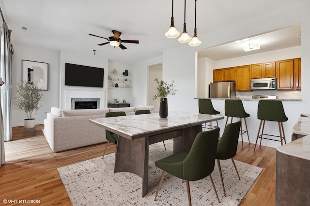 4727 N Clark St Unit 2S, Chicago, IL 60640 - dining area with ceiling fan, light wood finished floors, and a fireplace