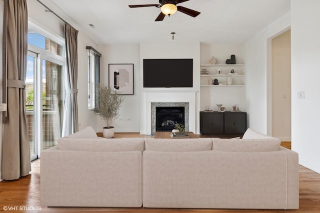 4727 N Clark St Unit 2S, Chicago, IL 60640 - living area with ceiling fan, light wood-style floors, built in shelves, and a glass covered fireplace