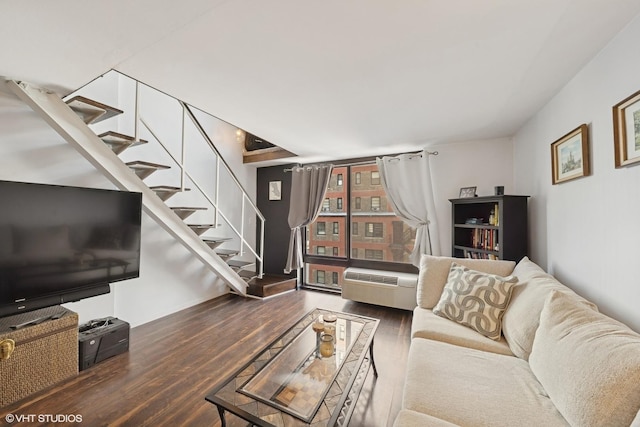 living area with wood finished floors, stairway, and a wall mounted AC