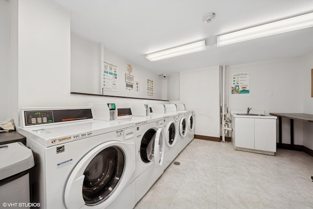 communal laundry room featuring washer and dryer and baseboards