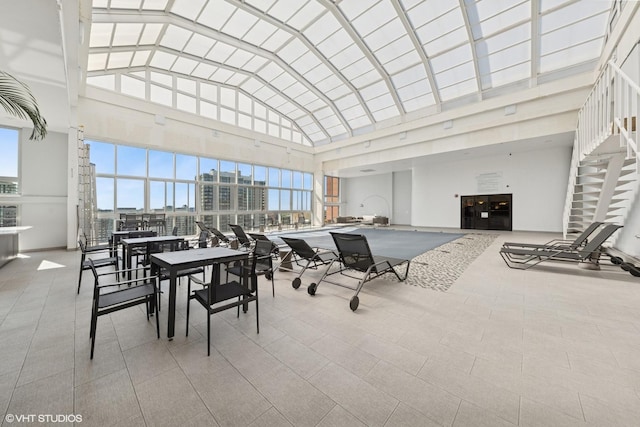 dining space with healthy amount of natural light, high vaulted ceiling, and a view of city