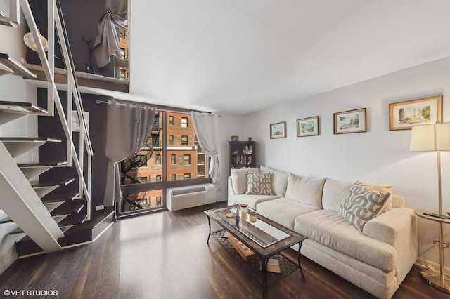 living area with wood finished floors and a wall unit AC