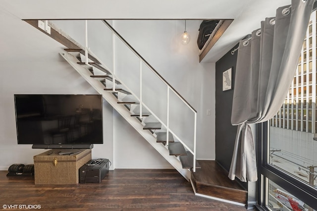 staircase featuring wood finished floors and baseboards