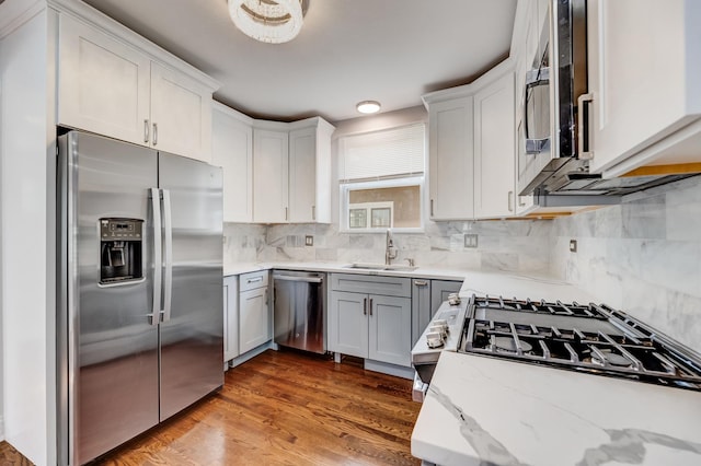 11311 S Stewart Ave, Chicago, IL 60628 - kitchen with stainless steel appliances, a sink, light stone countertops, tasteful backsplash, and wood finished floors