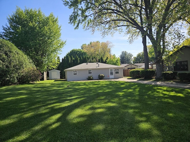 view of green lawn featuring a storage unit and an outbuilding