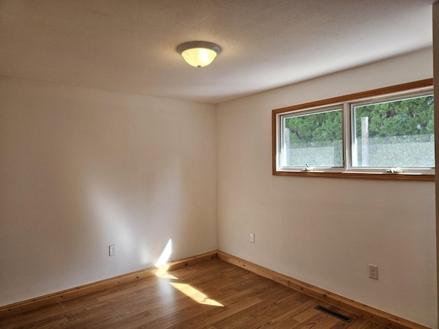 unfurnished room featuring wood finished floors and baseboards