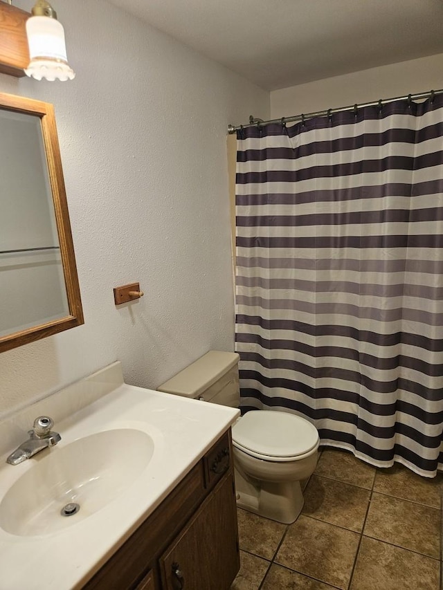 bathroom featuring toilet, vanity, tile patterned floors, and a shower with shower curtain