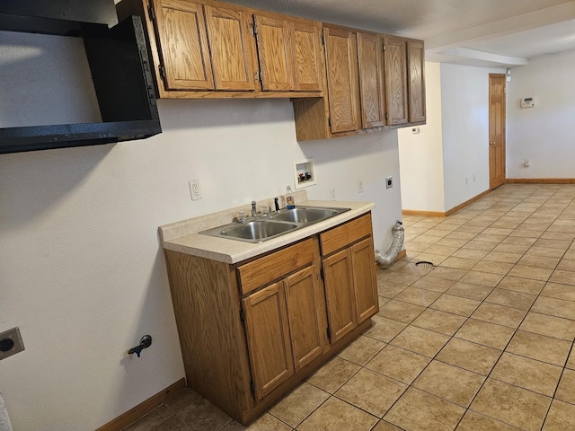 kitchen with a sink, light countertops, light tile patterned floors, and extractor fan