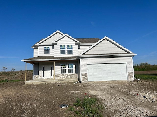 1415 Warwick, Savoy, IL 61874 - view of front of property featuring stone siding, a garage, covered porch, and dirt driveway