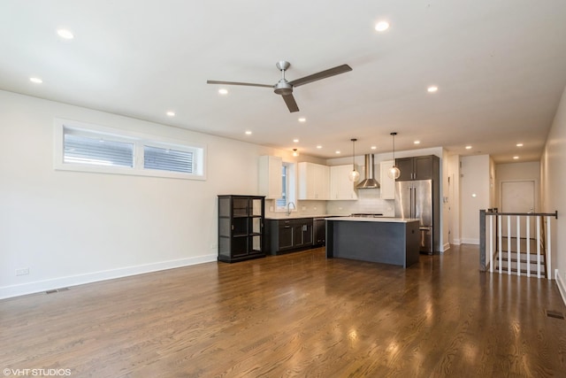unfurnished living room featuring ceiling fan, baseboards, recessed lighting, dark wood finished floors, and a sink