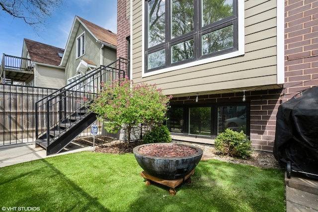 back of property featuring stairway and a yard