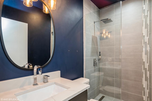 full bath featuring tiled shower and vanity