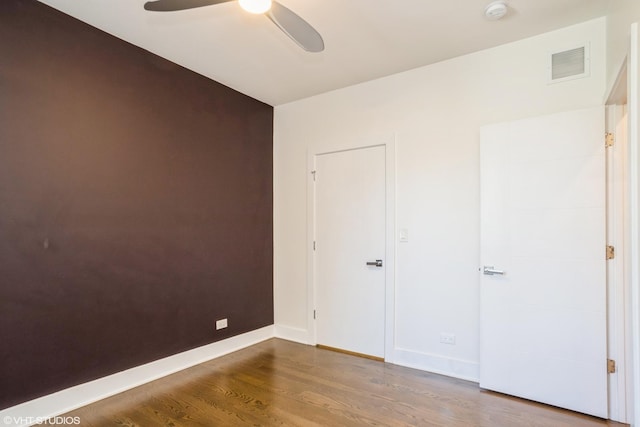 unfurnished bedroom with wood finished floors, baseboards, and a ceiling fan