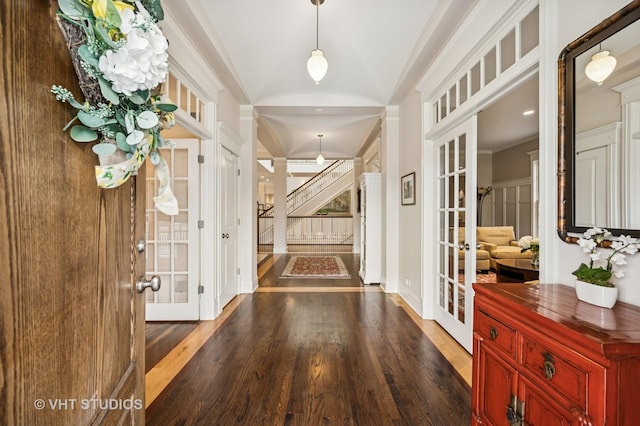 entrance foyer featuring french doors, wood finished floors, vaulted ceiling, and stairs