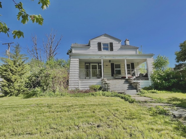 view of front facade featuring covered porch, a front yard, and a chimney