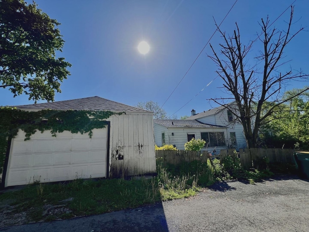 view of home's exterior with fence and an outdoor structure