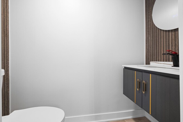 bathroom featuring baseboards, vanity, and toilet