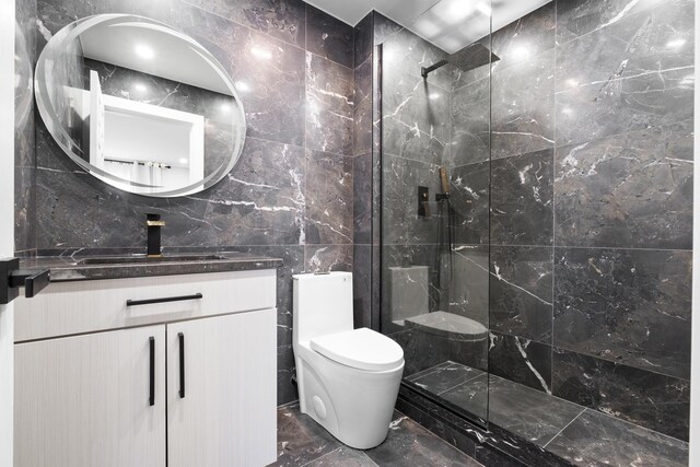 full bath with tile walls, marble tiled flooring, toilet, vanity, and a walk in shower