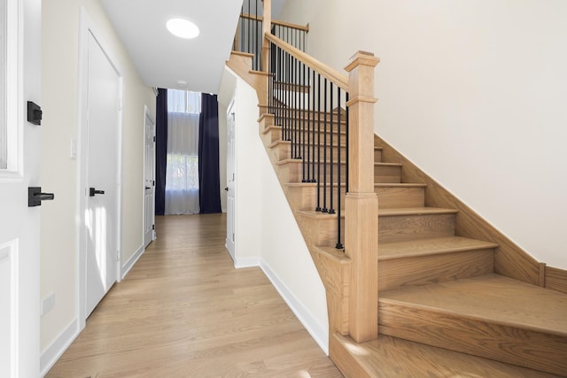 stairs with wood finished floors and baseboards