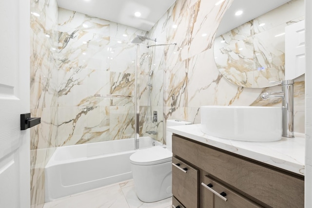 bathroom featuring toilet, shower / washtub combination, vanity, tile walls, and marble finish flooring