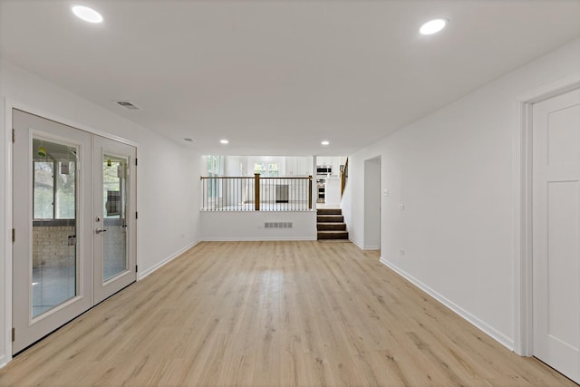 unfurnished living room with french doors, light wood-type flooring, recessed lighting, stairway, and baseboards