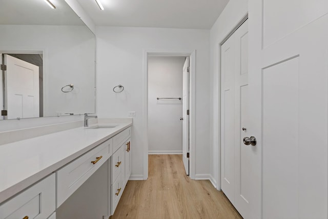 bathroom featuring wood finished floors, vanity, and baseboards