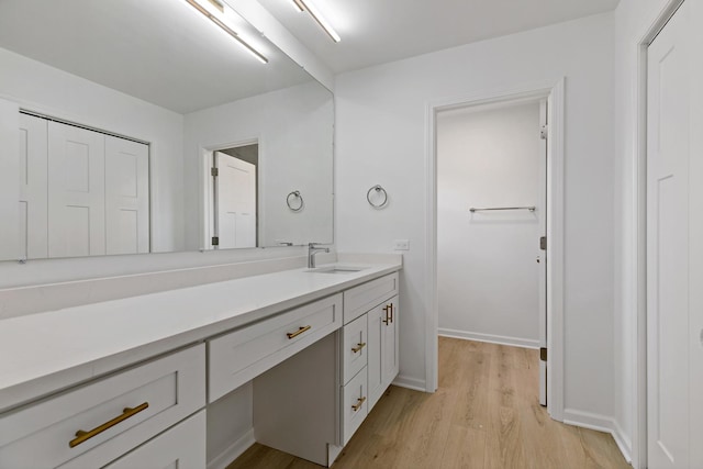 bathroom featuring wood finished floors, vanity, and baseboards