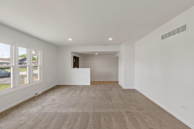 carpeted spare room featuring baseboards and recessed lighting