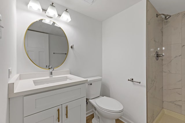 bathroom with toilet, a stall shower, and vanity