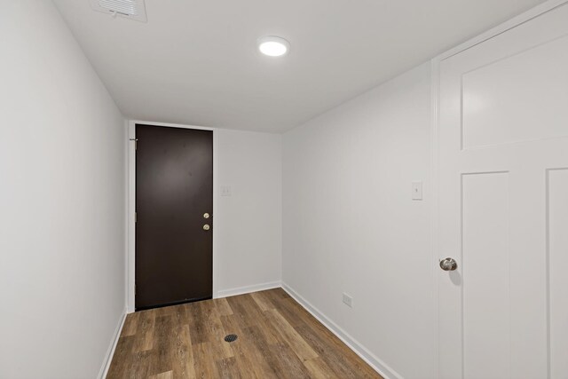 doorway with wood finished floors and baseboards
