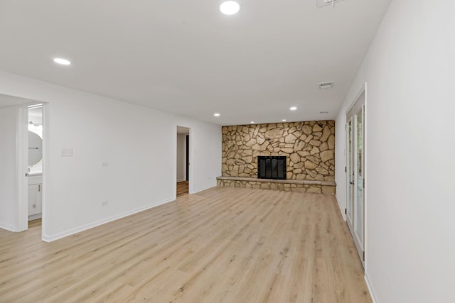 unfurnished living room with light wood-style flooring, recessed lighting, a fireplace, and baseboards