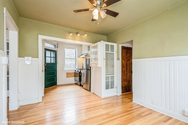 1225 W Jarvis Ave Unit 3, Chicago, IL 60626 - kitchen with stainless steel appliances, a wainscoted wall, light wood-style floors, under cabinet range hood, and ceiling fan