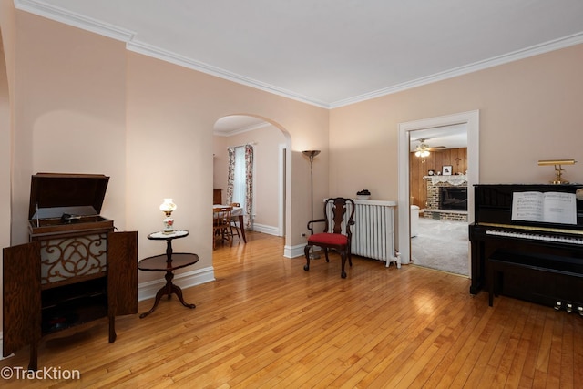 4929 Washington St, Downers Grove, IL 60515 - living area featuring arched walkways, light wood-style flooring, ceiling fan, crown molding, and a fireplace