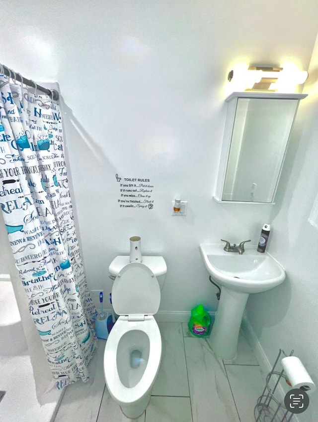 full bath featuring marble finish floors, a shower with shower curtain, baseboards, and toilet