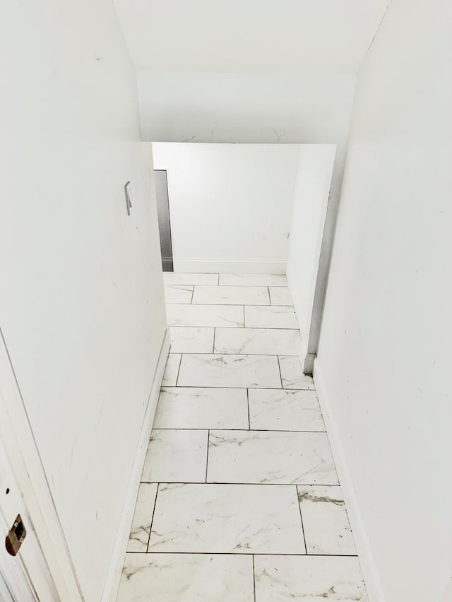 stairs featuring marble finish flooring and baseboards