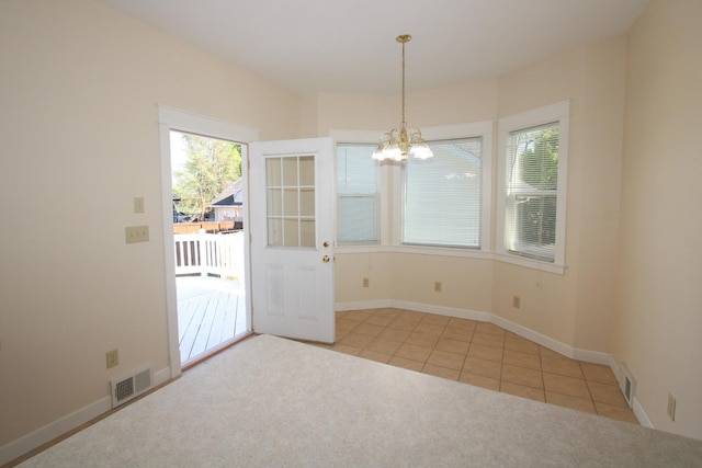 tiled spare room with healthy amount of natural light, a chandelier, carpet floors, and baseboards