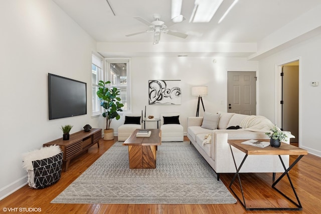 living room featuring ceiling fan, wood finished floors, and baseboards