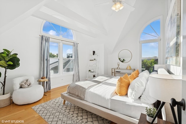 bedroom featuring multiple windows, light wood-type flooring, ceiling fan, and high vaulted ceiling