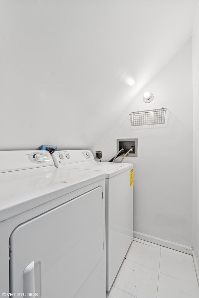 laundry area with washer and clothes dryer, light tile patterned floors, and baseboards
