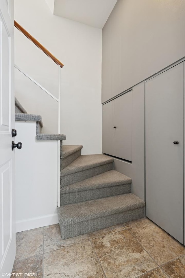 stairway featuring stone finish flooring