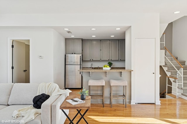 living room featuring light wood-type flooring, stairway, and recessed lighting