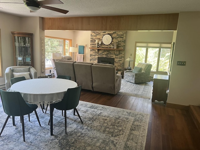 2493 W Mud Creek Rd, Mount Morris, IL 61054 - dining area with a ceiling fan, dark wood-style floors, a brick fireplace, healthy amount of natural light, and a textured ceiling