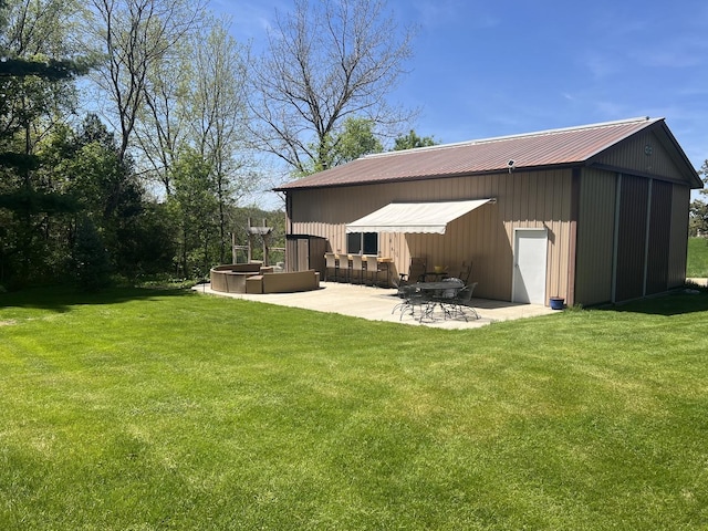 2493 W Mud Creek Rd, Mount Morris, IL 61054 - rear view of house featuring a yard, a patio, a garage, and metal roof