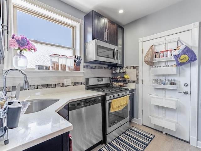 5717 N Kimball Ave Unit 2N, Chicago, IL 60659 - kitchen featuring appliances with stainless steel finishes, decorative backsplash, a sink, light stone countertops, and light wood-style floors