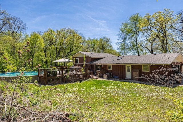 4182 Dawson Lake Rd, Poplar Grove, IL 61065 - back of property featuring a deck, a lawn, roof with shingles, an outdoor pool, and board and batten siding