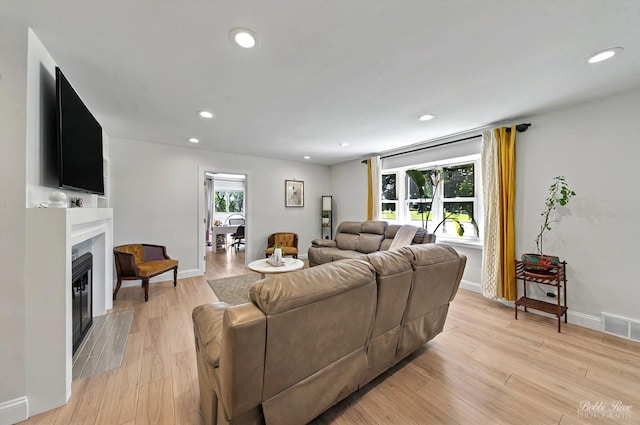 1224 S Mount Prospect Rd, Des Plaines, IL 60018 - living area with a glass covered fireplace, light wood finished floors, recessed lighting, and baseboards