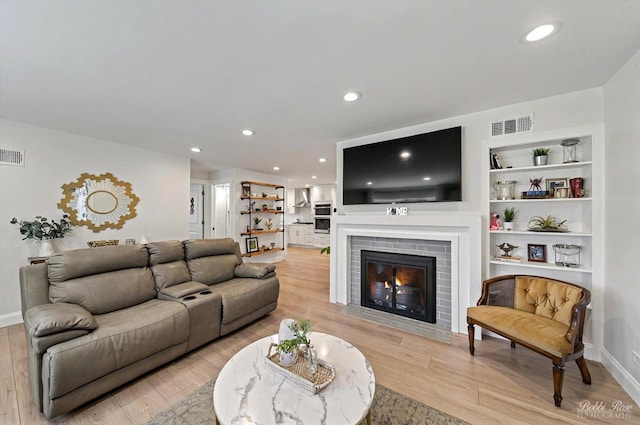 1224 S Mount Prospect Rd, Des Plaines, IL 60018 - living room featuring light wood-style flooring, a brick fireplace, baseboards, recessed lighting, and built in shelves