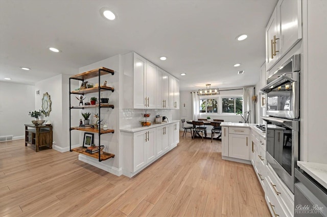 1224 S Mount Prospect Rd, Des Plaines, IL 60018 - kitchen with white cabinets, recessed lighting, light wood-style flooring, and tasteful backsplash