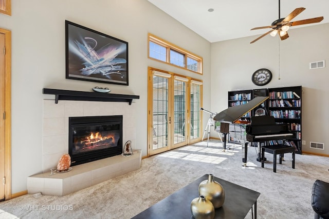 23803 E 3100 N Rd, Dwight, IL 60420 - carpeted living room with a towering ceiling, a tiled fireplace, a ceiling fan, and baseboards