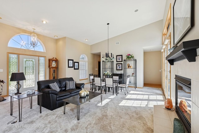 23803 E 3100 N Rd, Dwight, IL 60420 - living area with a chandelier, high vaulted ceiling, a tiled fireplace, light colored carpet, and baseboards